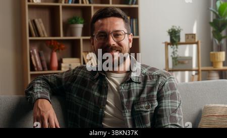 Portrait heureux souriant insouciant tête positive homme caucasien homme barbu gars dans des lunettes propriétaire de la santé dans son propre appartement sourire regardant la caméra Banque D'Images