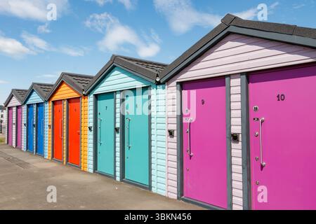 Toilettes publiques colorées sans contact conçues comme des cabanes de plage dans une rangée avec des portes vibrantes et des numéros seaton carew, co. durham Banque D'Images