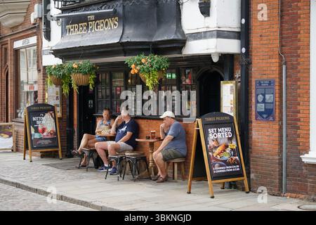 Les gens se détendent à l'extérieur d'un pub britannique confortable avec sièges extérieurs. Guildford, Angleterre Banque D'Images