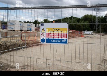 Panneau d'avertissement de danger sur une clôture entourant un nouveau chantier de construction de logements interdisant au public et aux enfants d'entrer Banque D'Images