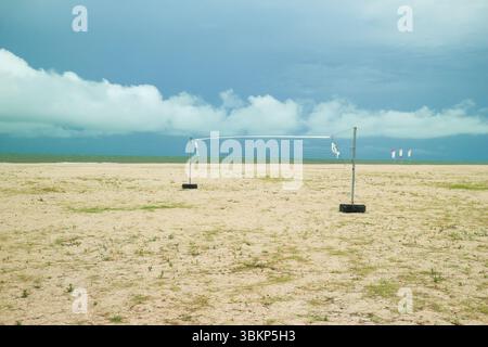 Terrain de Beach volley vide sous un ciel bleu vif avec des nuages éparpillés. Côte tropicale sereine en Asie du Sud-est. Banque D'Images