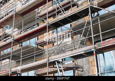 Échafaudage sur façade de bâtiment de construction. Plate-forme provisoire en acier pour rénovation ou entretien. Travaux de développement urbain et de restauration. Banque D'Images