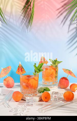 Nature morte moderne avec martini, cocktail alcoolisé, baies de pêche, d'abricot et de menthe sur fond moderne élégant, concept minimaliste pour bar et holid Banque D'Images