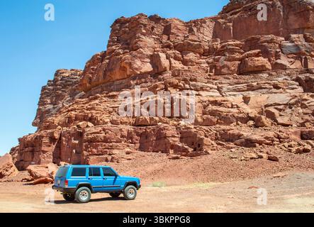 Alula, Arabie Saoudite, 3 avril 2024. Vue d'une voiture bleue au site du patrimoine d'Alula Dadan avec des tombes et des montagnes rocheuses en arrière-plan dans une journée ensoleillée. Banque D'Images