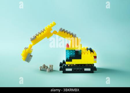 Jouet excavateur assemblé avec fond cyan Banque D'Images