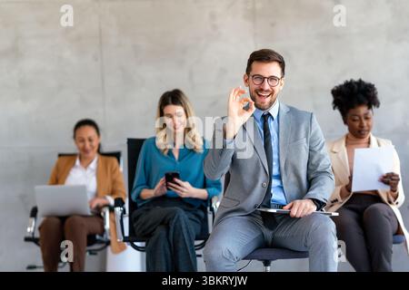 Heureux hommes d'affaires riant tout en collaborant sur un nouveau projet dans un bureau. Banque D'Images
