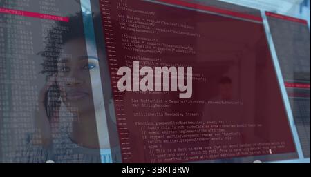 Analyse du développeur tenant un smartphone et regardant le code teinté en rouge sur un panneau transparent dans le bureau Banque D'Images