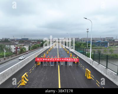 Suzhou. 23 juin 2025. Une photo de drone montre des travailleurs posant pour des photos lors de l'ouverture des voies de gauche du pont de Pingwang nouvellement construit dans le district de Wujiang de la ville de Suzhou, dans la province du Jiangsu de l'est de la Chine, le 23 juin 2025. Les voies de gauche du pont de Pingwang nouvellement construit, un projet de la partie est du projet d'amélioration du canal de navigation de Chang-Hu-Shen (Changxin-Huzhou-Shanghai) (section Jiangsu), ont été officiellement ouvertes à la circulation lundi. Crédit : Ji Chunpeng/Xinhua/Alamy Live News Banque D'Images