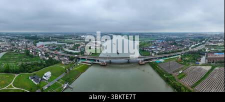 Suzhou. 23 juin 2025. Une photo prise par un drone aérien le 23 juin 2025 montre une vue du pont de Pingwang dans le district de Wujiang de la ville de Suzhou, dans la province du Jiangsu de l'est de la Chine. Les voies de gauche du pont de Pingwang nouvellement construit, un projet de la partie est du projet d'amélioration du canal de navigation de Chang-Hu-Shen (Changxin-Huzhou-Shanghai) (section Jiangsu), ont été officiellement ouvertes à la circulation lundi. Crédit : Ji Chunpeng/Xinhua/Alamy Live News Banque D'Images