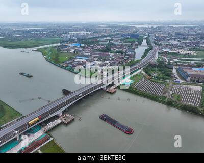 Suzhou. 23 juin 2025. Une photo prise par un drone aérien le 23 juin 2025 montre une vue du pont de Pingwang dans le district de Wujiang de la ville de Suzhou, dans la province du Jiangsu de l'est de la Chine. Les voies de gauche du pont de Pingwang nouvellement construit, un projet de la partie est du projet d'amélioration du canal de navigation de Chang-Hu-Shen (Changxin-Huzhou-Shanghai) (section Jiangsu), ont été officiellement ouvertes à la circulation lundi. Crédit : Ji Chunpeng/Xinhua/Alamy Live News Banque D'Images