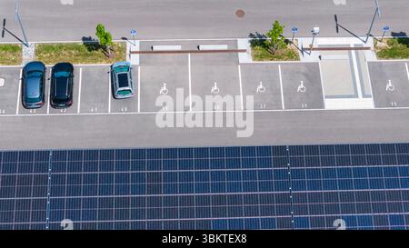 Behindertenparkplatz. Größter Ladepark der Welt am Bahnhof Merklingen/Schwäbische Alb 259 überdachte Stationen für Elektroautos finden sich unter zwei 160 und 190 Meter langen Dächern. Der Zweckverband Schwäbische Alb und das Land investieren für den Ladepark rund fünf Millionen Euro. // 21.05.2025, Merklingen, Bade-Württemberg, Deutschland. *** Espace de stationnement pour handicapés le plus grand parc de recharge du monde à la station de Merklingen Swabian Alb 259 stations couvertes pour voitures électriques sont situées sous deux toits de 160 et 190 mètres de long L'association souabienne Alb et l'État investissent Banque D'Images