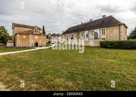 Juste à côté du Baptistère Saint-Jean (Baptistère Saint-Jean, Baptistère Saint-Jean) sur la Rue Jean-Jaurès à Poitiers, en Nouvelle-Aquitaine, France, se trouve le Musée Sainte-Croix (Musée de la Sainte-Croix), le plus grand musée de la ville. À droite se dresse un long bâtiment à toit en croupe, sa façade décorée de grandes bannières montrant des images monochromes. À gauche se trouve le baptistère avec ses toits de tuiles rouges, et un chemin traverse la pelouse. Le musée a ouvert ses portes en 1974 sur le site de l'ancienne abbaye Sainte-Croix. Il abrite des expositions permanentes extensives sur l'archéologie, l'art et l'histoire. La Sainte- Banque D'Images