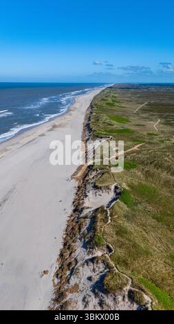 De vastes plages de sable s'étendent le long de la côte de Denmarks, rencontrant la mer bleue cristalline. Des dunes verdoyantes et des falaises rocheuses créent un paysage naturel époustouflant sous un ciel lumineux. Banque D'Images