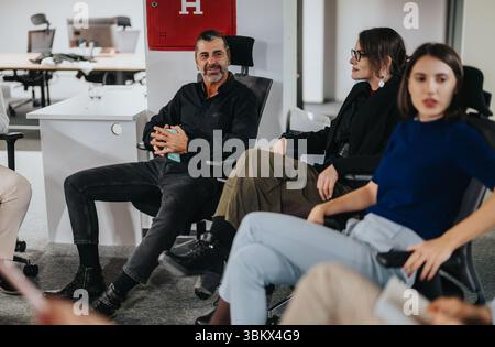 Équipe commerciale engagée dans une discussion de bureau animée avec l'accent sur le travail d'équipe Banque D'Images