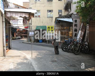 Man Walking Down the Street, Tai O Fishing Village, Hong Kong, Chine Banque D'Images