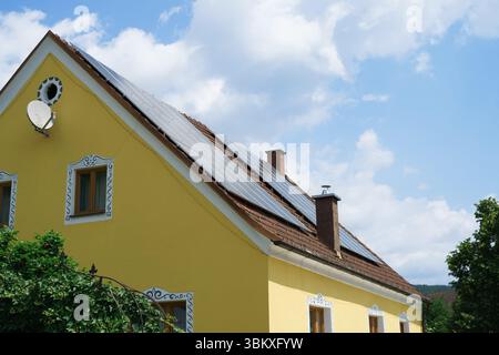 Vue latérale des panneaux solaires installés sur le toit d'une maison privée. Sources d'énergie écologiques Banque D'Images