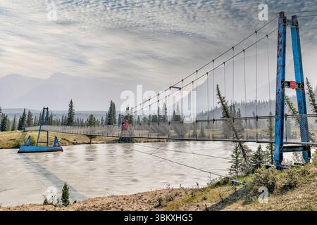 Une mère et son fils debout sur la passerelle qui enjambe la rivière Sakatchewan Sud menant aux chutes Siffleur dans la réserve écologique des plaines Kootenay Banque D'Images