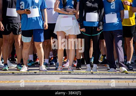 Grand groupe de coureurs, athlètes à la ligne de départ quelques secondes avant le début de leur course, dans une compétition de marathon de rue, foule de gens en attente de course Banque D'Images
