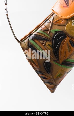 Sac à main orange fait à la main sur un fond blanc, sac à main en cuir orange fait à la main, sac à main artisanal en or orange avec une poignée courte en chaîne Banque D'Images