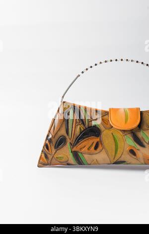 Sac à main orange fait à la main sur un fond blanc, sac à main en cuir orange fait à la main, sac à main artisanal en or orange avec une poignée courte en chaîne Banque D'Images