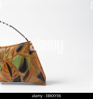 Sac à main orange fait à la main sur un fond blanc, sac à main en cuir orange fait à la main, sac à main artisanal en or orange avec une poignée courte en chaîne Banque D'Images