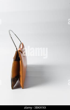 Sac à main orange fait à la main sur un fond blanc, sac à main en cuir orange fait à la main, sac à main artisanal en or orange avec une poignée courte en chaîne Banque D'Images