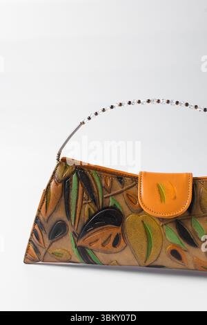 Sac à main orange fait à la main sur un fond blanc, sac à main en cuir orange fait à la main, sac à main artisanal en or orange avec une poignée courte en chaîne Banque D'Images
