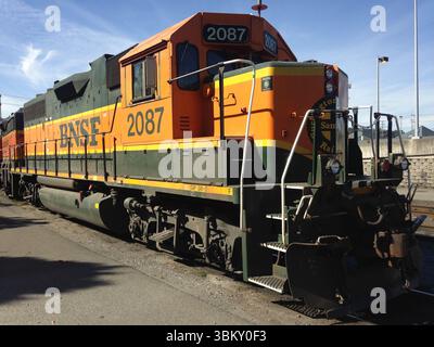 Une locomotive diesel de fret BNSF tourne au ralenti dans le chantier naval de Seattle—peinture jaune-vert audacieuse et forme puissante mettant en valeur le fret ferroviaire moderne sur le Pacific Northwe Banque D'Images