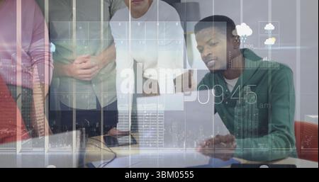 Équipe de cinq collègues examinant les superpositions numériques des ordinateurs portables dans un bureau moderne, avec des papiers Banque D'Images