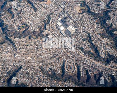 Une vue aérienne montre une zone suburbaine densément peuplée avec des maisons et des routes, mettant en évidence l'urbanisme et la vie résidentielle. Banque D'Images