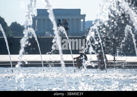 Washington, États-Unis. 23 juin 2025. Les gens se rafraîchissent près d'une fontaine pendant une vague de chaleur à Washington, DC, aux États-Unis, le 23 juin 2025. Crédit : HU Yousong/Xinhua/Alamy Live News Banque D'Images