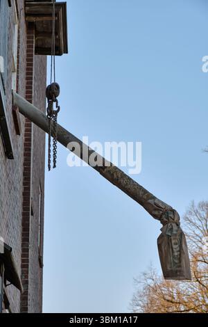 28 mars 2025 - Miste-pays-Bas : façade de l'usine d'alimentation Meenkmolen avec treuil de levage, chute et sac dans l'ombre du soir. Banque D'Images