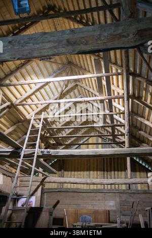 Un bâtiment en bois avec une échelle sur le côté. L'échelle est appuyée contre le mur. Le bâtiment est vieux et a une atmosphère rustique Banque D'Images