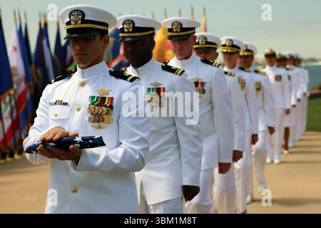 Les marins avec le drapeau défilent en formation pour effectuer la cérémonie de passage du drapeau lors d'une cérémonie de retraite pour le capitaine Aric et Rachel Baudek à Naval base point Loma, San Diego, le 20 juin 2025. Les Baudeks ont pris leur retraite après 49 années combinées de service en tant qu'infirmières de la Marine, plus récemment avec les systèmes de médecine expéditionnaire au camp de préparation et de commandement de la Marine Medicine de Pendleton. (Photo de l'US Navy par Arsenio R. Cortez Jr.) Banque D'Images