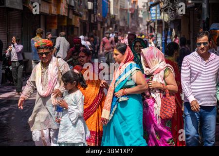 Inde, Jaipur, 22 mars 2025. Scène de rue colorée pendant le festival Holi avec des hommes, des femmes et des enfants marchant à travers la vieille ville de Jaipur dans le fe traditionnel Banque D'Images