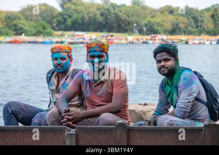 Inde, Jaipur, 22 mars 2025. Trois hommes couverts de poudre bleue pendant les célébrations du festival Holi au bord du lac à Jaipur. Portrait franc du festival. Banque D'Images