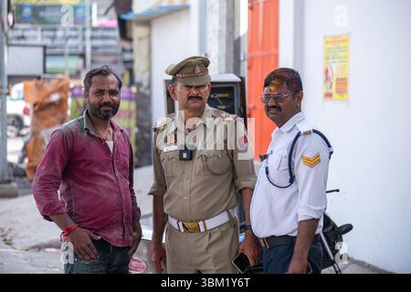 Inde, Jaipur, 22 mars 2025. Policier, agent de la circulation et résident local posent pour une photo dans les rues de Jaipur pendant la célébration du festival Holi Banque D'Images