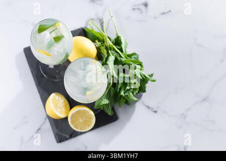 Cocktail Hugo avec citron, menthe et glace dans un verre à vin sur fond de marbre Banque D'Images