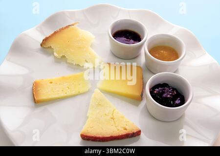 Différents types de fromages servis avec du miel et de la confiture, créant une délicieuse combinaison de saveurs et de textures, parfaite pour une expérience de dégustation Banque D'Images