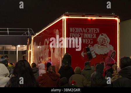 Une foule de personnes prenant des photos d'un camion de Noël Coca-Cola décoré de guirlandes LED. Autriche, Vienne, 13 décembre 2024 Banque D'Images