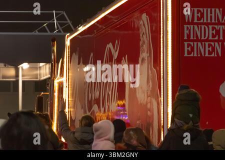 Une camionnette rouge Coca-Cola de la Saint-Sylvestre illuminée de lumières ravit les spectateurs. Autriche, Vienne, 13 décembre 2024 Banque D'Images