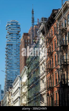 Greene Street dans le quartier historique de Soho présente des façades en fonte contrastant avec l'architecture moderne en arrière-plan, 2025, NYC, USA Banque D'Images