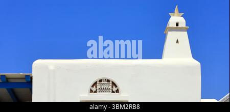 Bâtiments modernes blanchis à la chaux avec des motifs traditionnels tiniens, île de Tinos, le groupe d'îles des Cyclades, Grèce. Prise mai / juin 2025 printemps Banque D'Images