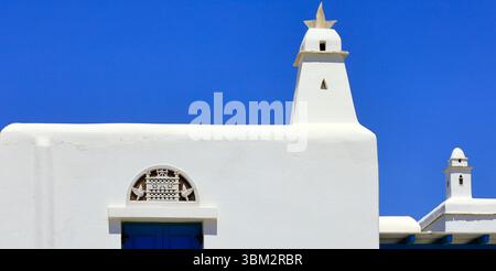 Bâtiments modernes blanchis à la chaux avec des motifs traditionnels tiniens, île de Tinos, le groupe d'îles des Cyclades, Grèce. Prise mai / juin 2025 printemps Banque D'Images