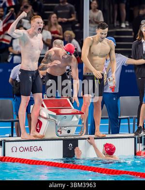 James Guy (GBR), Duncan Scott (GBR), Tom Dean (GBR) et Matthew Richards (GBR) célèbrent leur victoire sur la médaille d'or au Relais libre 4 X 200 m masculin à l'arène de la Défense de Paris lors des Jeux olympiques d'été de 2024 à Paris, France. Banque D'Images