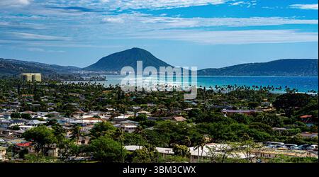 Vue aérienne de la magnifique côte d'Honolulu, où les eaux turquoises rencontrent les plages de sable et les gratte-ciel de la ville, encadrés par des montagnes luxuriantes Banque D'Images