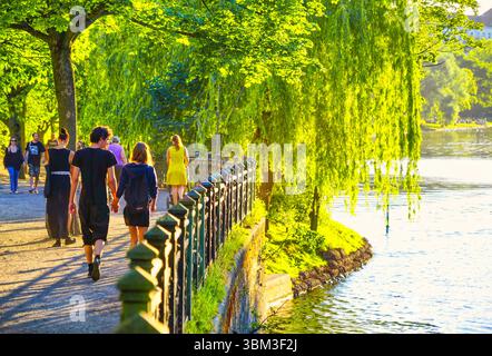 Jeune couple aime une promenade romantique le long du front de mer Landwehrkanal bordée d'arbres dans la lumière dorée, quartier de Kreuzberg, Berlin, Allemagne Banque D'Images