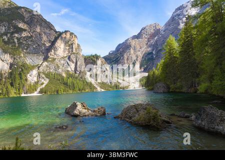 Un coin captivant du lac Braies avec ses eaux turquoises cristallines, ses rochers éparpillés et son décor spectaculaire de montagnes imposantes et escarpées Banque D'Images
