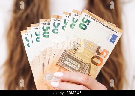 Femme tenant des billets en euros à la main. Concept financier d'épargne et d'investissement. Gros plan de la monnaie euro. Contexte économique. Monnaie européenne. Banque D'Images