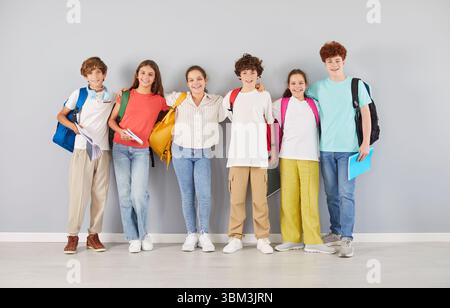 Heureux les écoliers preteen dans des vêtements colorés serrés et souriants ensemble, faisant photo de groupe. Banque D'Images